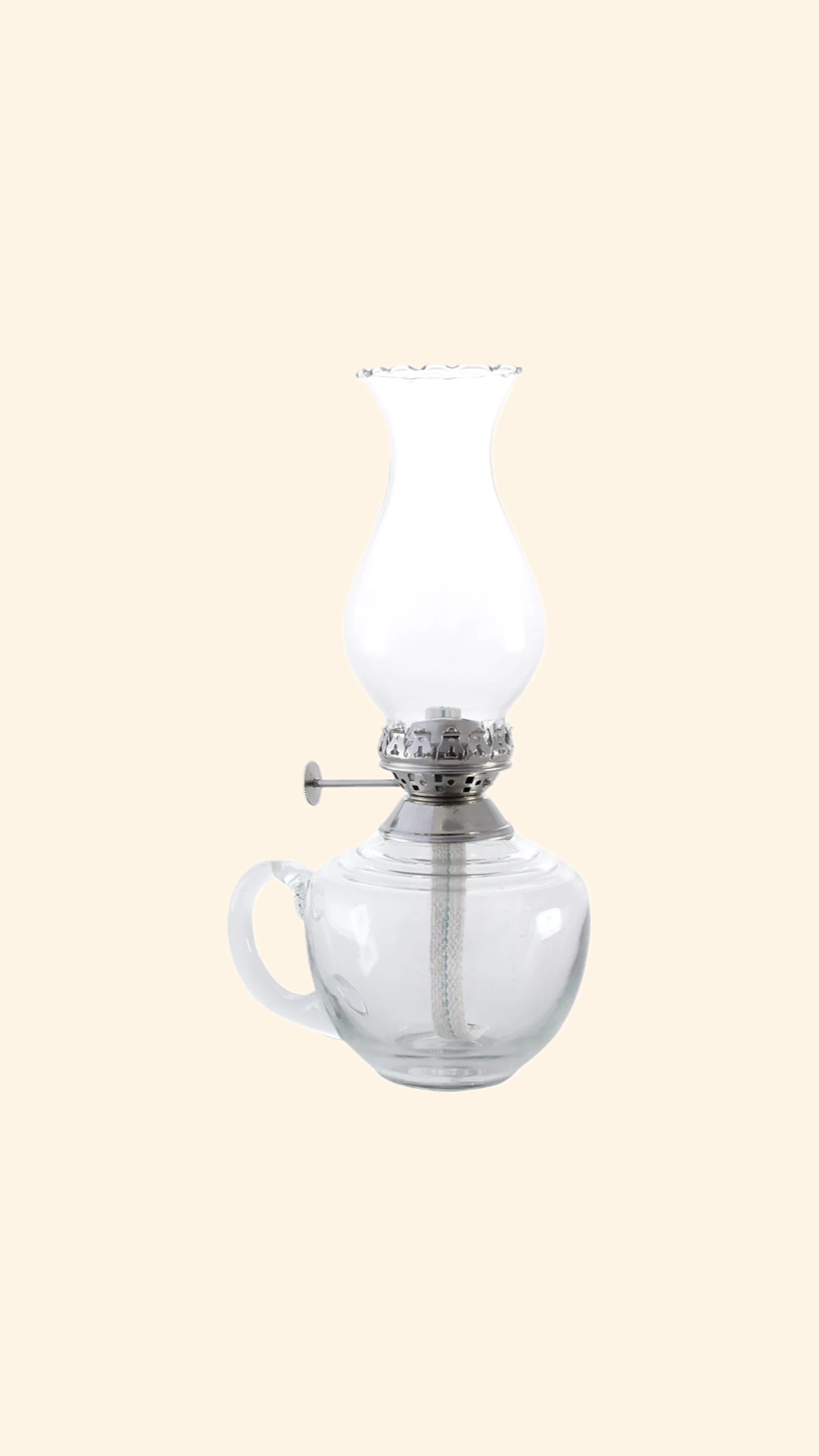 Fotogenlampa låg i klarglas med handtag och silverfärgad brännare. 